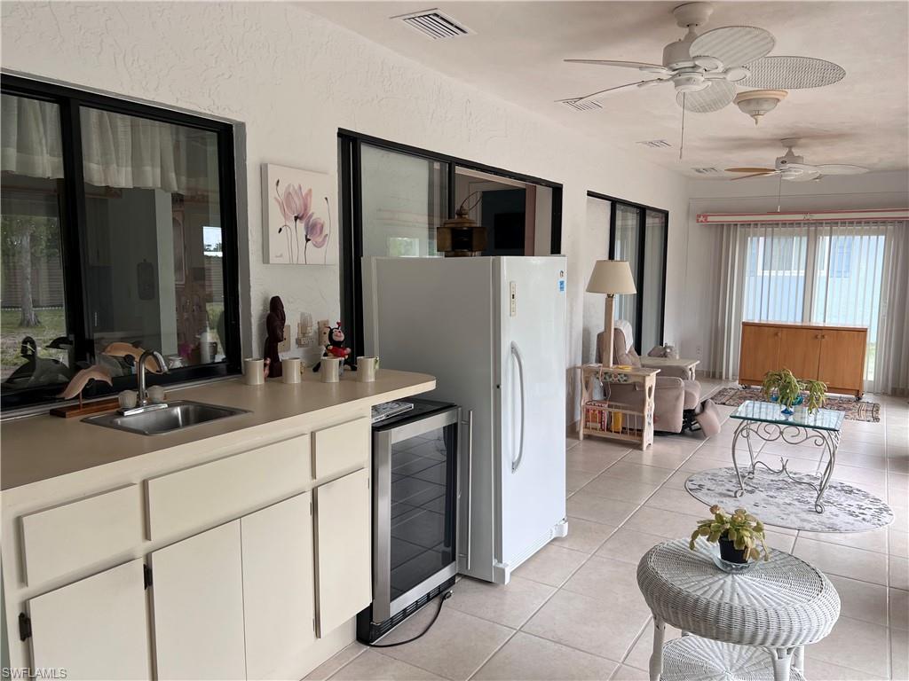 140 Bordeaux Circle Naples, FL 34112 - Photo 18 of 22 a living room with stainless steel appliances furniture a flat screen tv and a large window