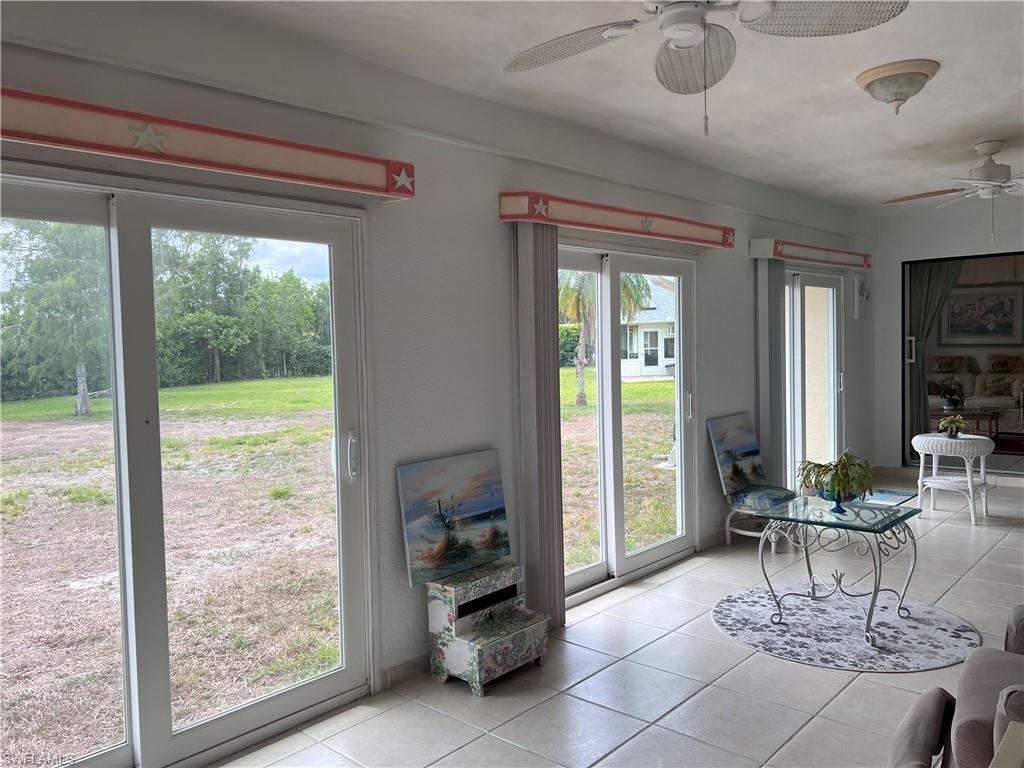 140 Bordeaux Circle Naples, FL 34112 - Photo 22 of 22 a living room with furniture and a floor to ceiling window