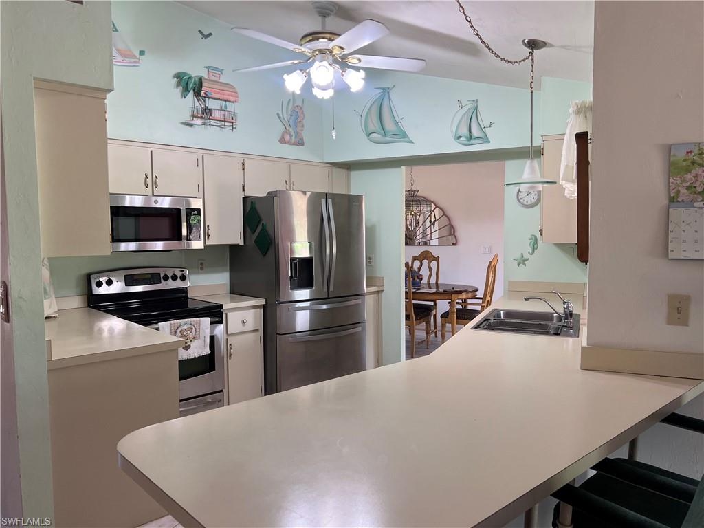 140 Bordeaux Circle Naples, FL 34112 - Photo 8 of 22 a kitchen with stainless steel appliances a stove refrigerator and a sink