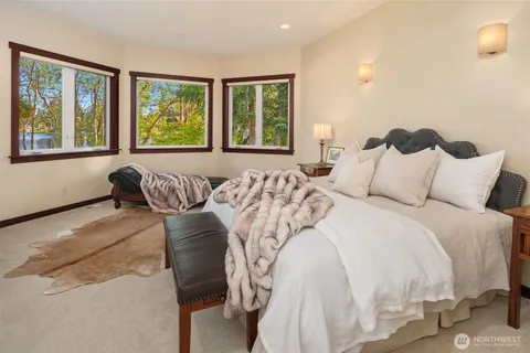 a bathroom with a granite countertop double vanity sink a large mirror a bathtub and a window