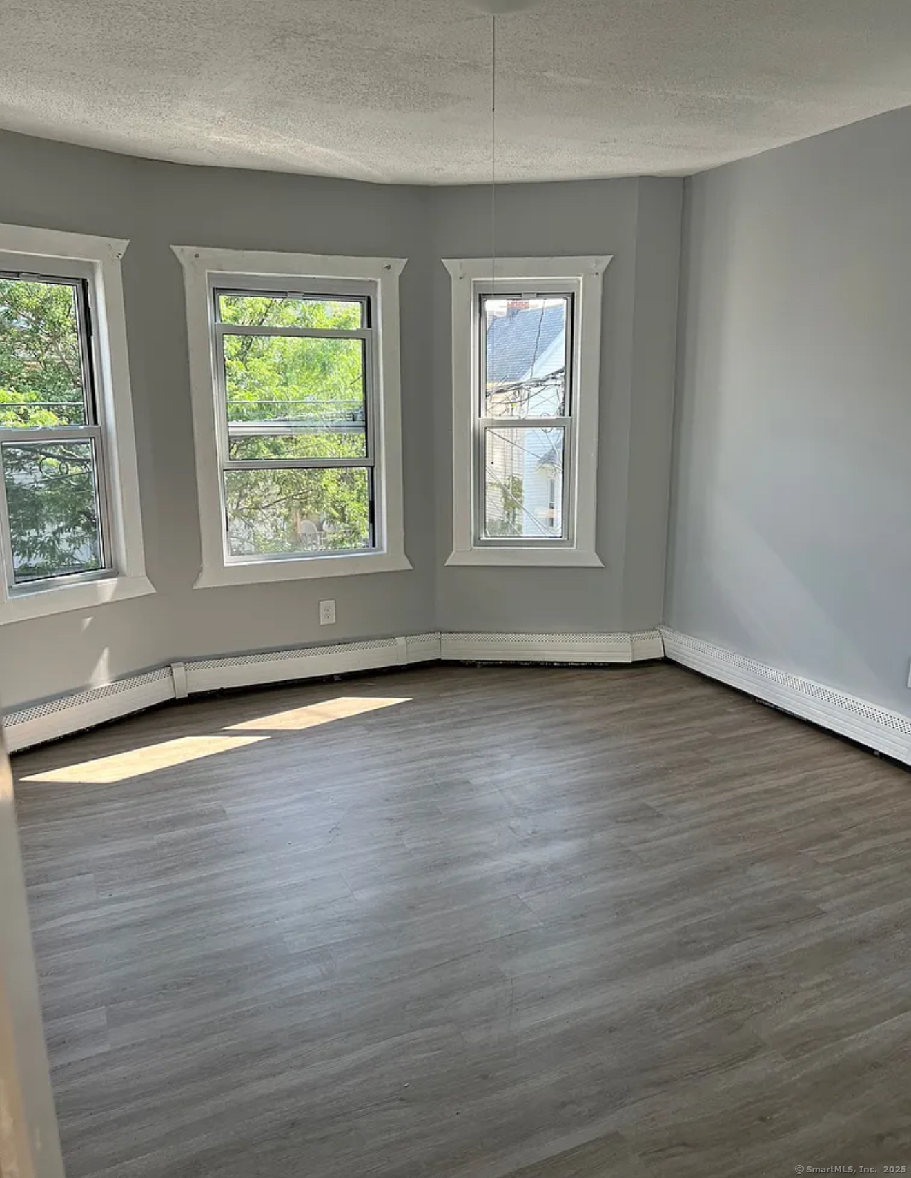 651 Maple Street, Unit 2 Bridgeport, CT 06608 - Photo 3 of 4 an empty room with wooden floor and windows
