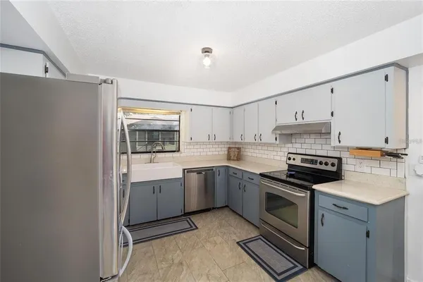 a kitchen with a sink stove and cabinets