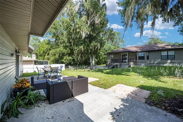 a view of a house with backyard sitting area and garden