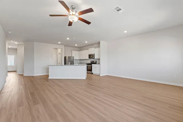 a view of a kitchen with a microwave and wooden floor