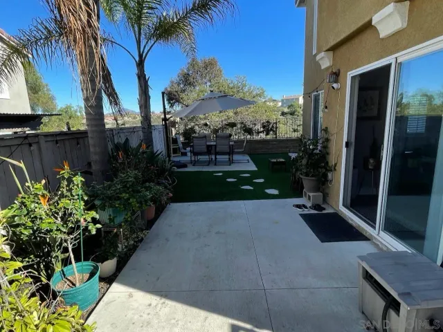 a view of a patio with table and chairs under an umbrella