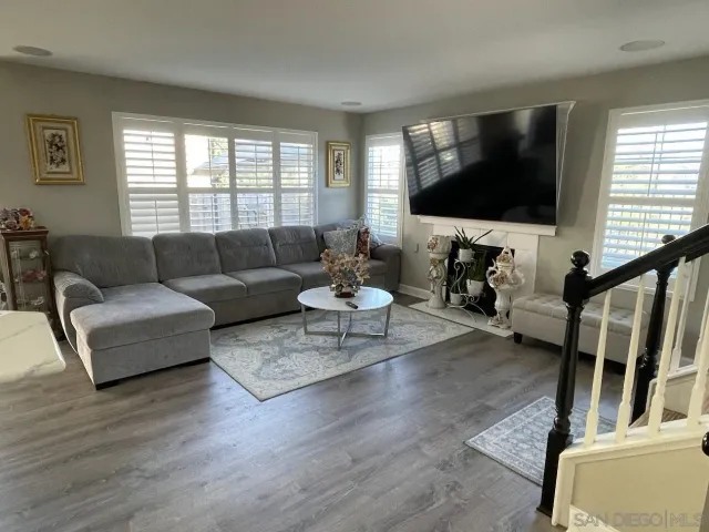 a living room with furniture flat screen tv and window