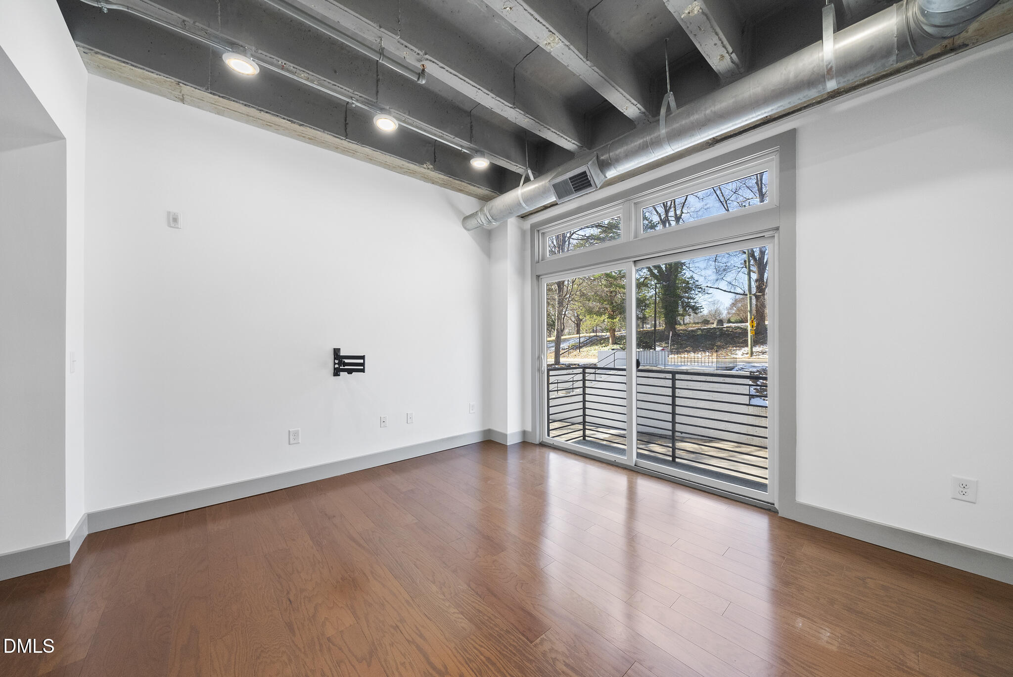 1300 St Marys Street, Unit 207 Raleigh, NC 27605 - Photo 11 of 18 an empty room with wooden floor and windows