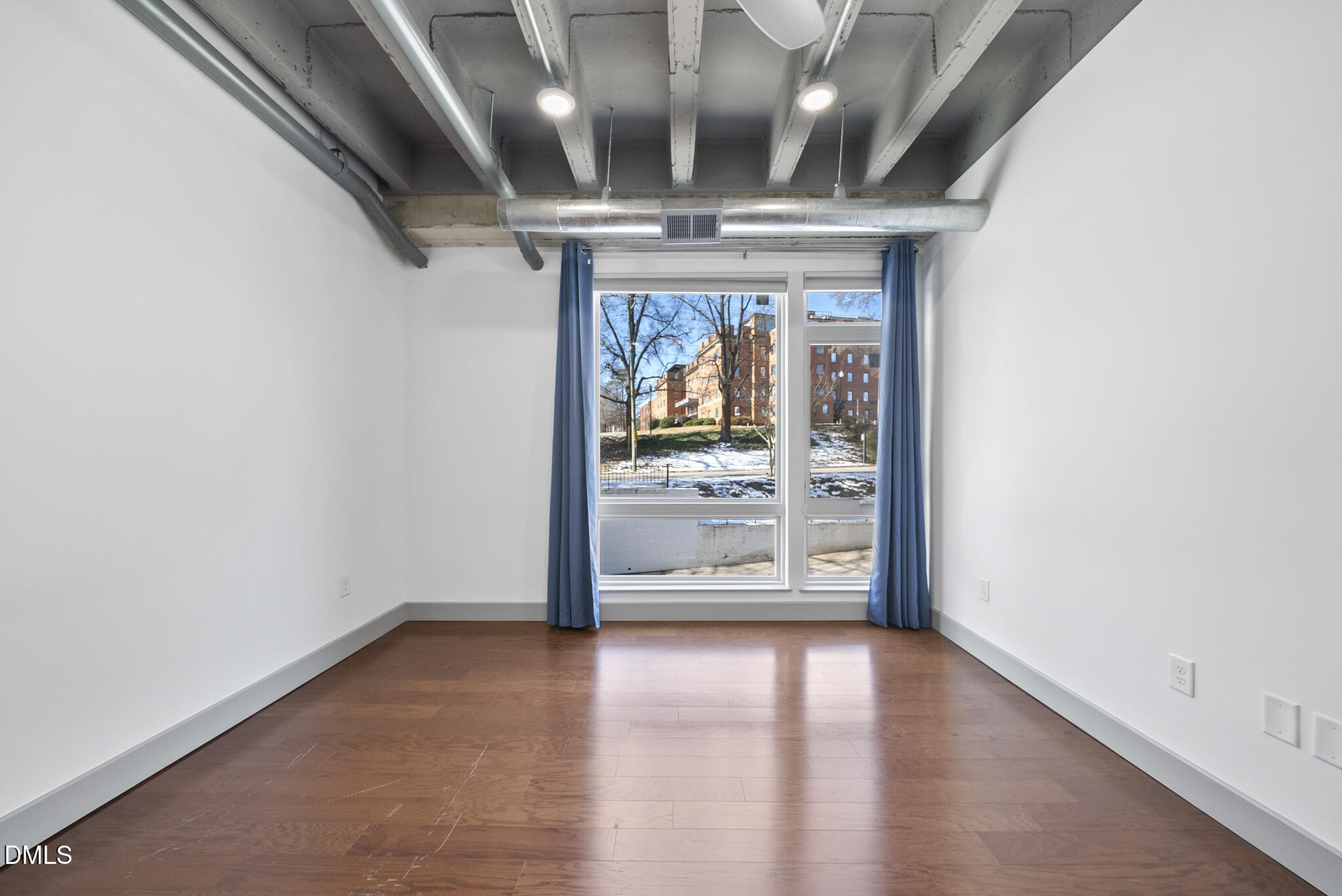1300 St Marys Street, Unit 207 Raleigh, NC 27605 - Photo 13 of 18 an empty room with wooden floor and windows