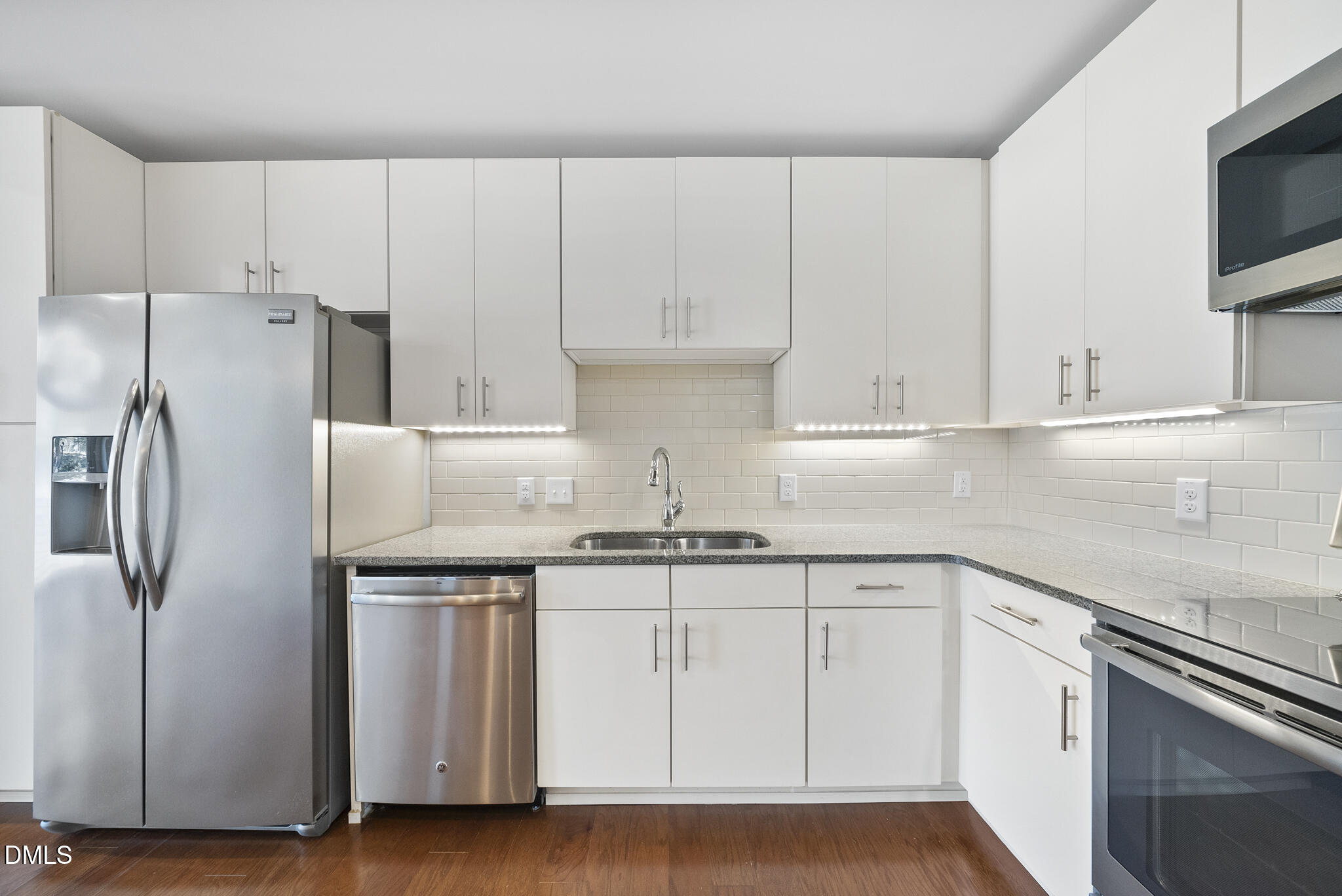 1300 St Marys Street, Unit 207 Raleigh, NC 27605 - Photo 7 of 18 a kitchen with white cabinets and stainless steel appliances