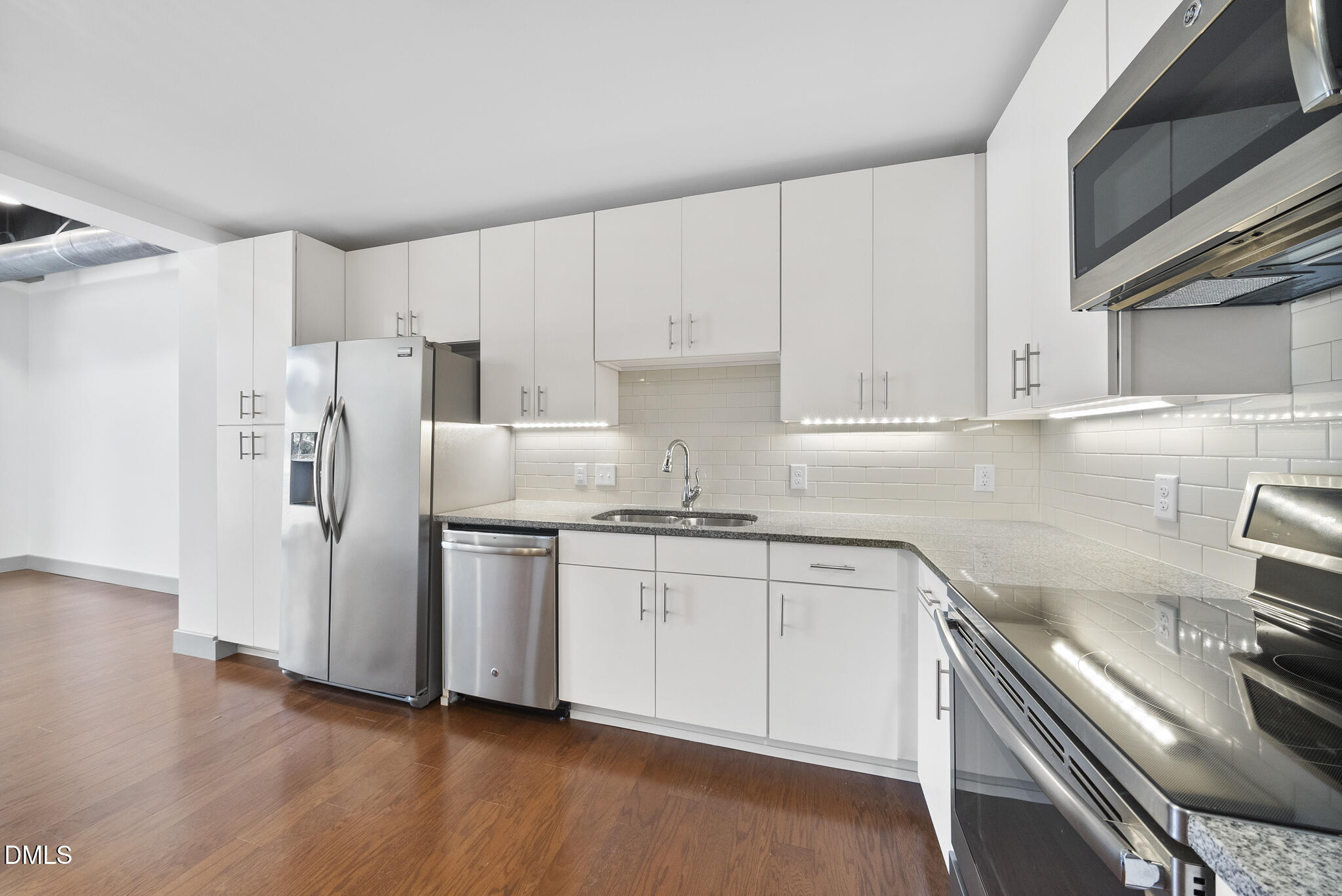 1300 St Marys Street, Unit 207 Raleigh, NC 27605 - Photo 8 of 18 a kitchen with stainless steel appliances granite countertop a refrigerator and a stove top oven