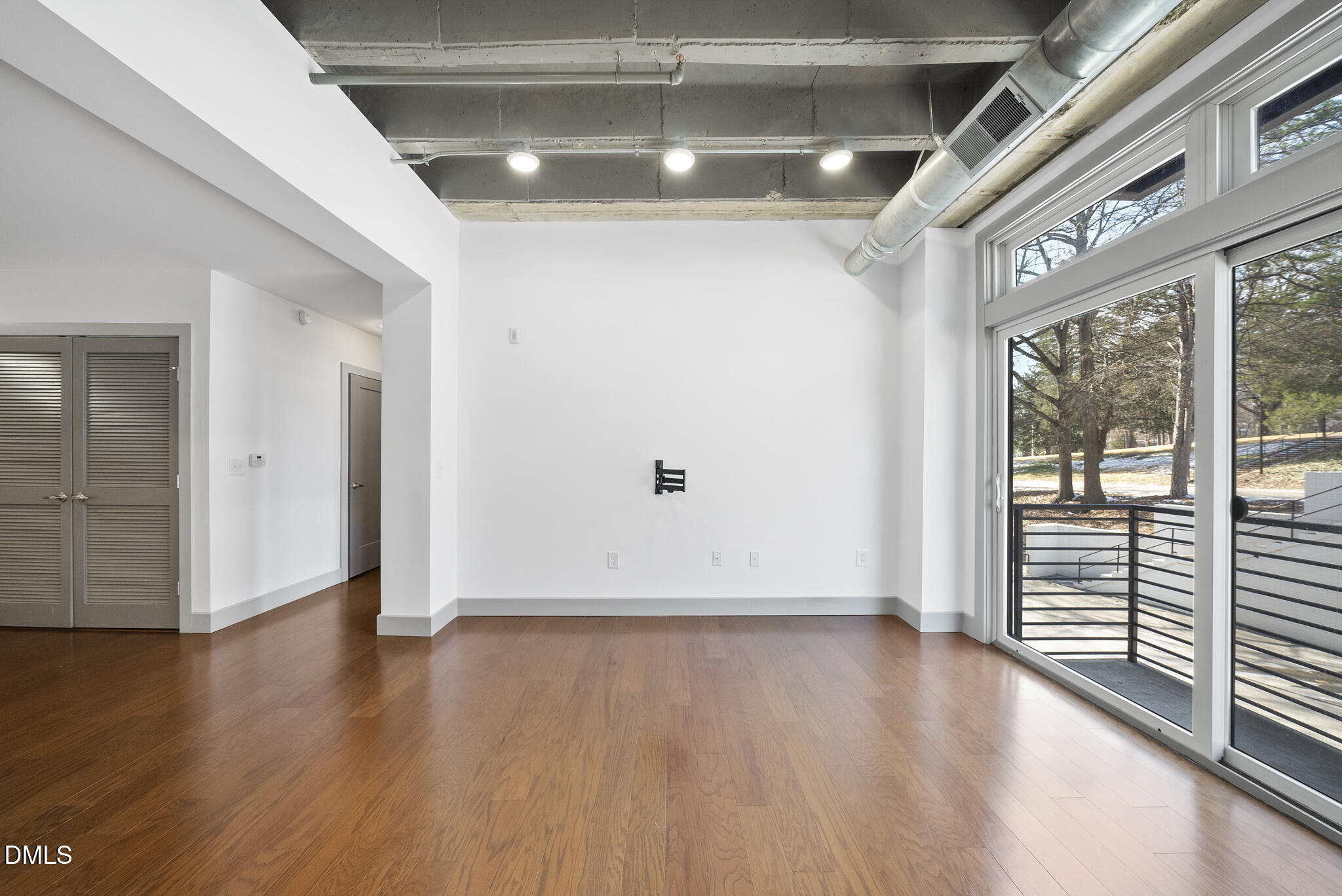 1300 St Marys Street, Unit 207 Raleigh, NC 27605 - Photo 9 of 18 a view of an empty room with wooden floor and a window