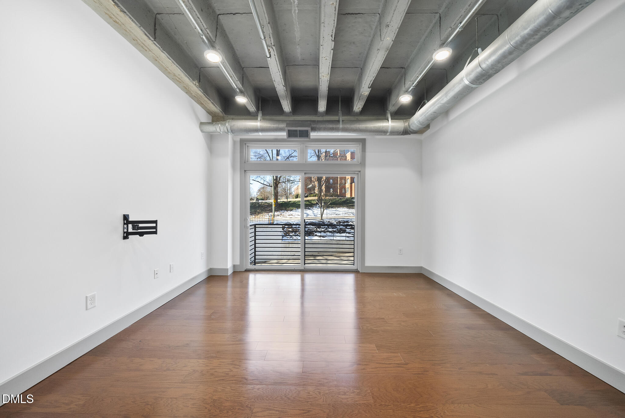 1300 St Marys Street, Unit 207 Raleigh, NC 27605 - Photo 10 of 18 an empty room with wooden floor and windows