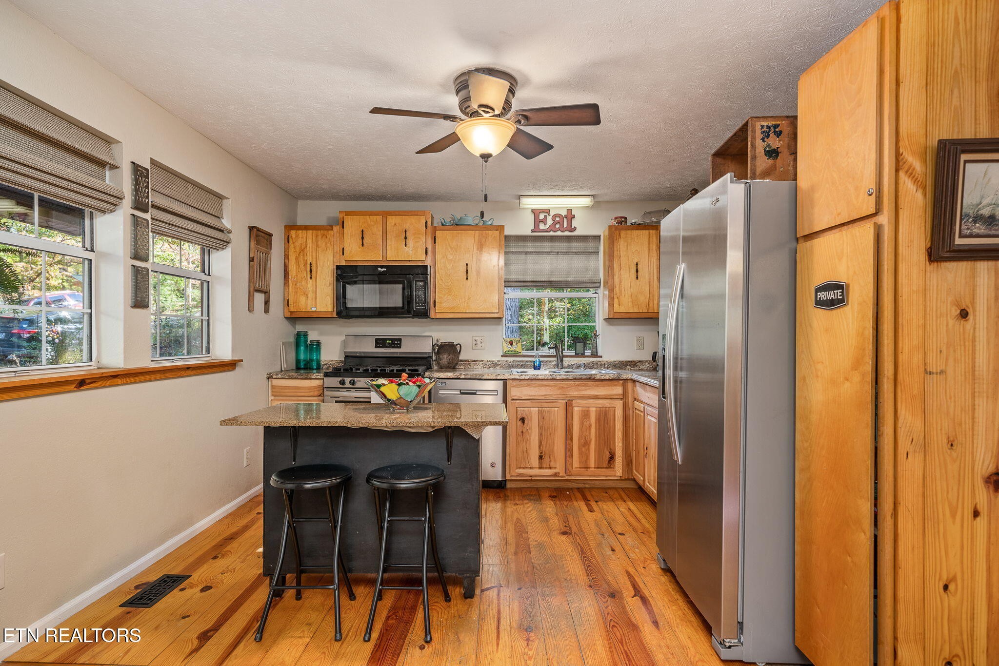 279 Siever Road Crossville, TN 38572 - Photo 10 of 35 a kitchen with stainless steel appliances granite countertop wooden floors a stove and a refrigerator
