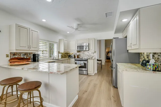 a kitchen with appliances a sink and cabinets