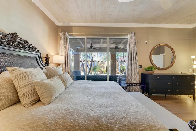 a bedroom with a bed large window with couch and dresser