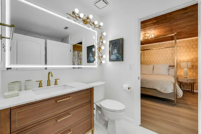 a en suite bathroom with a granite countertop double vanity sink a mirror and a shower