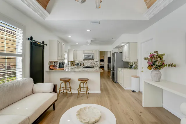 a living room with stainless steel appliances kitchen island granite countertop furniture and a kitchen view