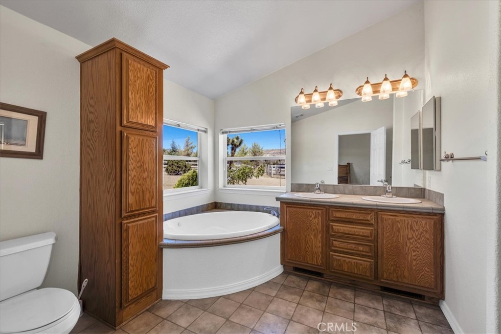 5175 Tom Mix Road Pioneertown, CA 92268 - Photo 25 of 58 a bathroom with a granite countertop sink toilet and a mirror
