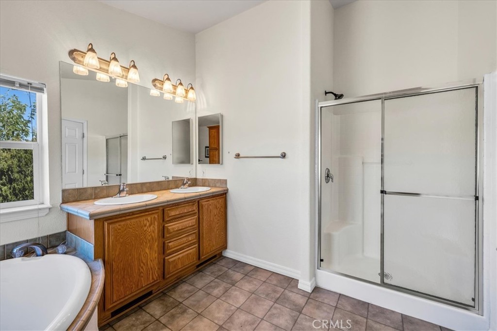 5175 Tom Mix Road Pioneertown, CA 92268 - Photo 26 of 58 a bathroom with a granite countertop sink a mirror and a shower