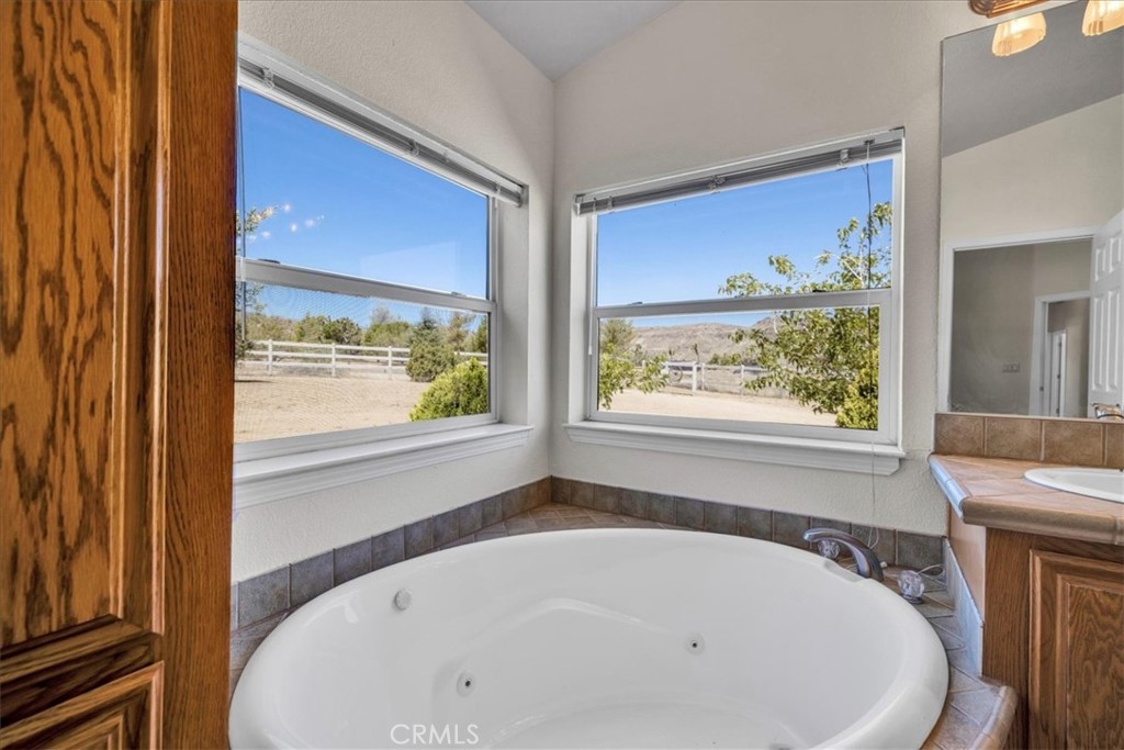 5175 Tom Mix Road Pioneertown, CA 92268 - Photo 27 of 58 a white bath tub sitting in a bathroom next to a window