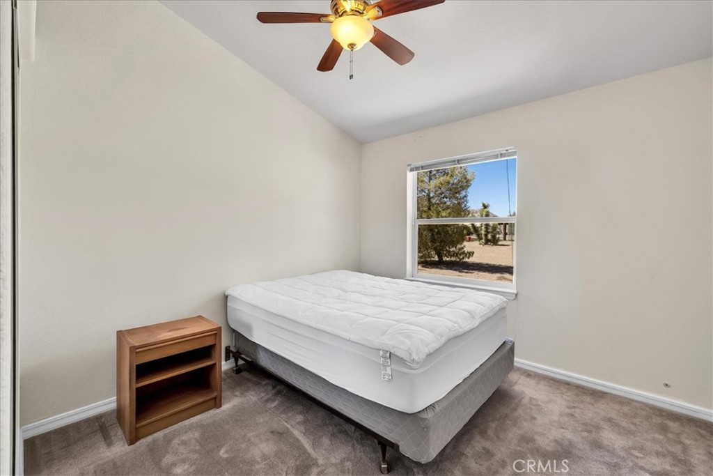 5175 Tom Mix Road Pioneertown, CA 92268 - Photo 28 of 58 a bedroom with a bed and a chandelier