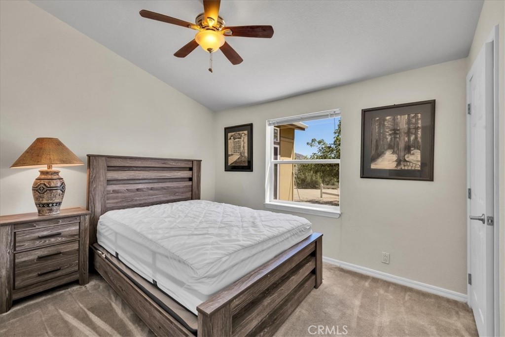 5175 Tom Mix Road Pioneertown, CA 92268 - Photo 31 of 58 a bedroom with a bed and a chandelier