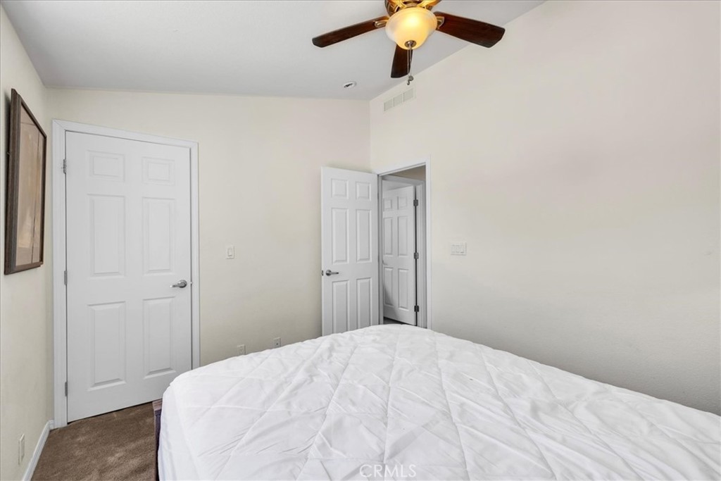 5175 Tom Mix Road Pioneertown, CA 92268 - Photo 32 of 58 a bedroom with a bed and a chandelier fan