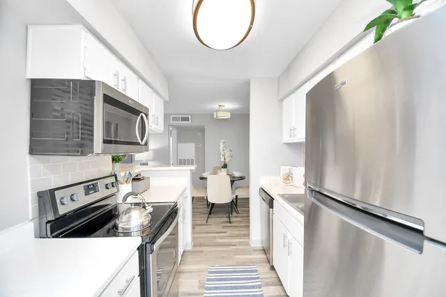 a kitchen with a white stove refrigerator and cabinets
