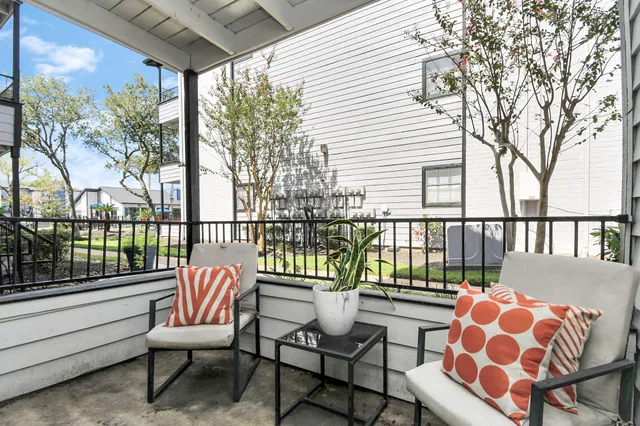a balcony with wooden benches and glass door