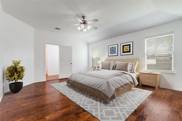 a spacious bedroom with a large bed and a chandelier