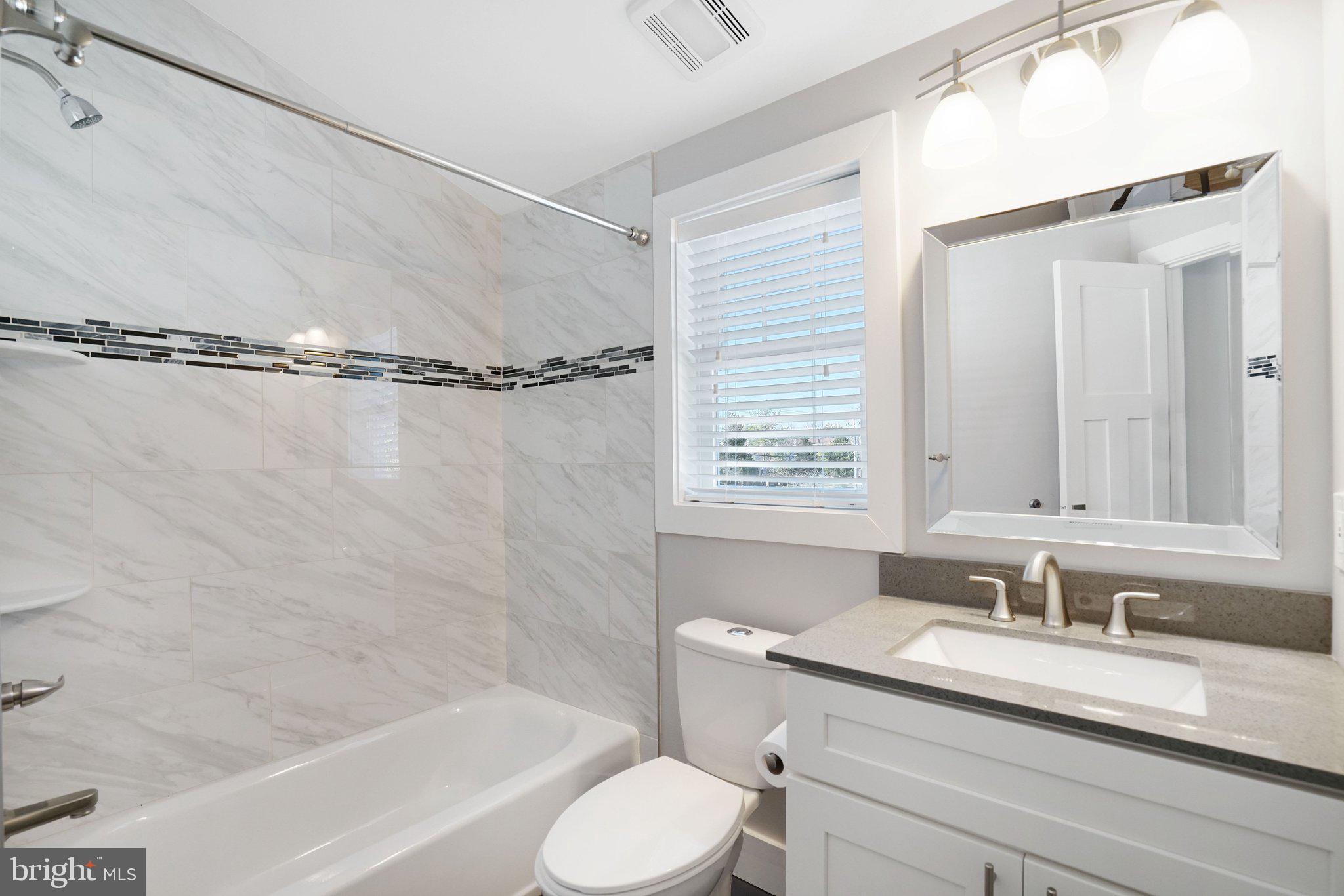 3731 Duke Street Alexandria, VA 22304 - Photo 30 of 57 a bathroom with a granite countertop sink toilet a mirror and shower