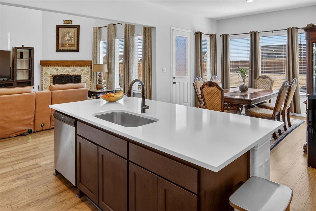 157 Misty Mountain Lane Rhome, TX 76078 - Photo 40 of 40 Kitchen with a fireplace, light wood-style flooring, dark wood finish cabinetry, and open floor plan