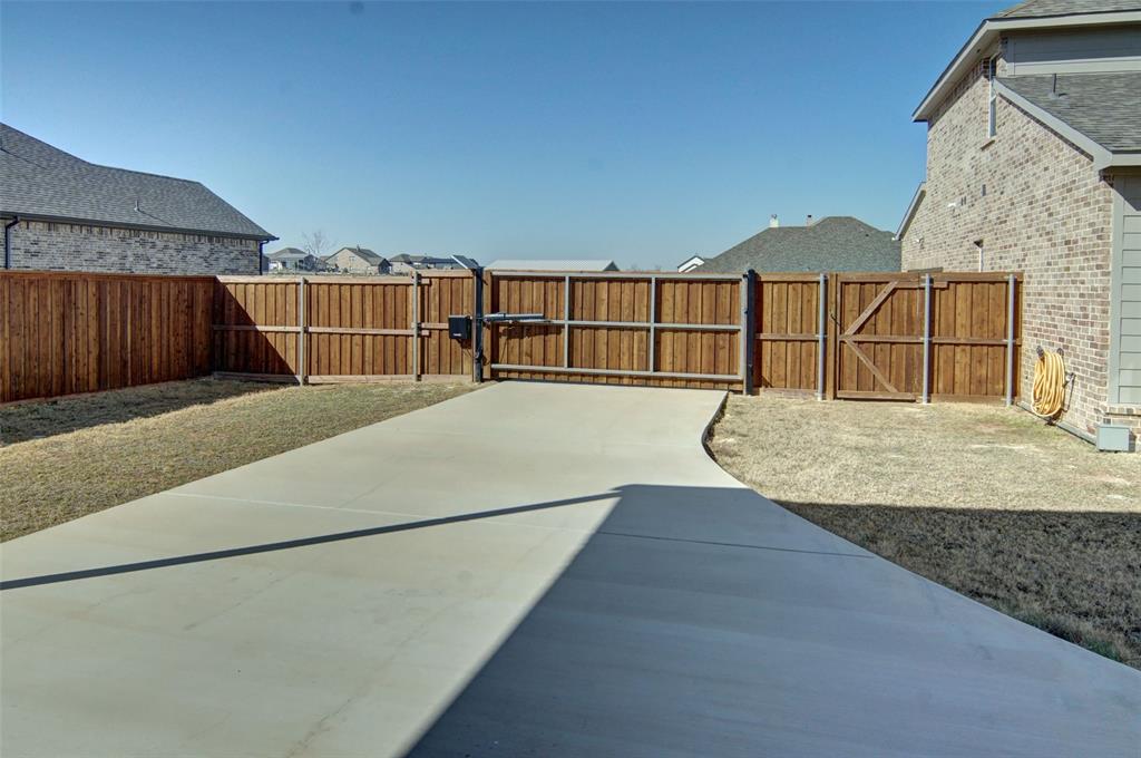 157 Misty Mountain Lane Rhome, TX 76078 - Photo 34 of 40 Fenced backyard featuring a solar powered automatic gate and amazing concrete driveway