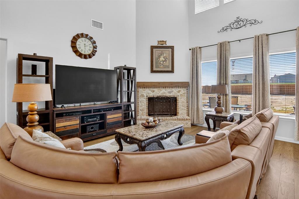157 Misty Mountain Lane Rhome, TX 76078 - Photo 6 of 40 Living area with a stone fireplace, light wood-type flooring, and a high ceiling