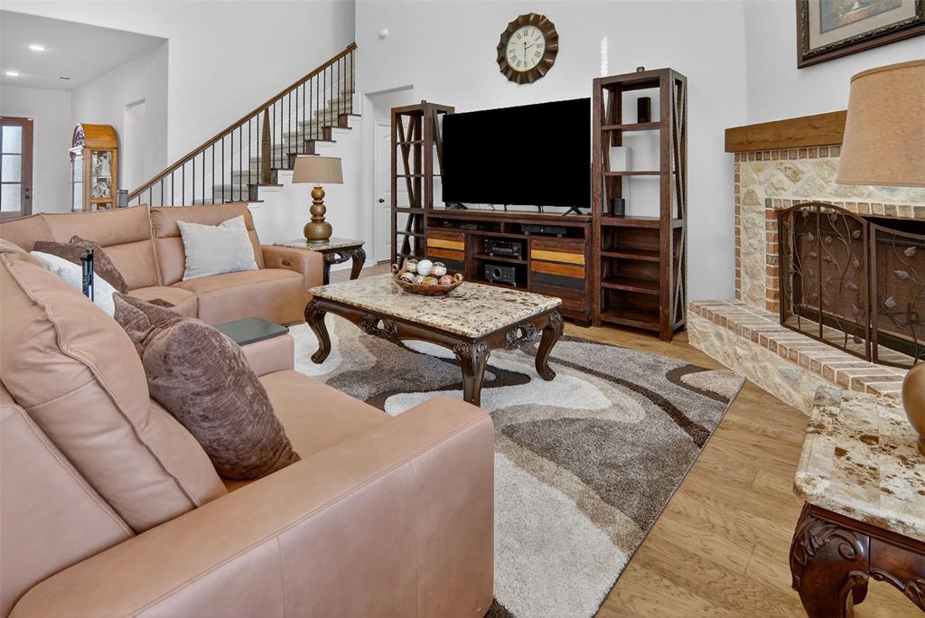 157 Misty Mountain Lane Rhome, TX 76078 - Photo 7 of 40 Living room featuring light wood-type flooring, a brick fireplace, recessed lighting, and a high ceiling