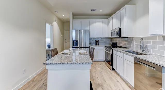 a kitchen with stainless steel appliances granite countertop a sink stove and refrigerator