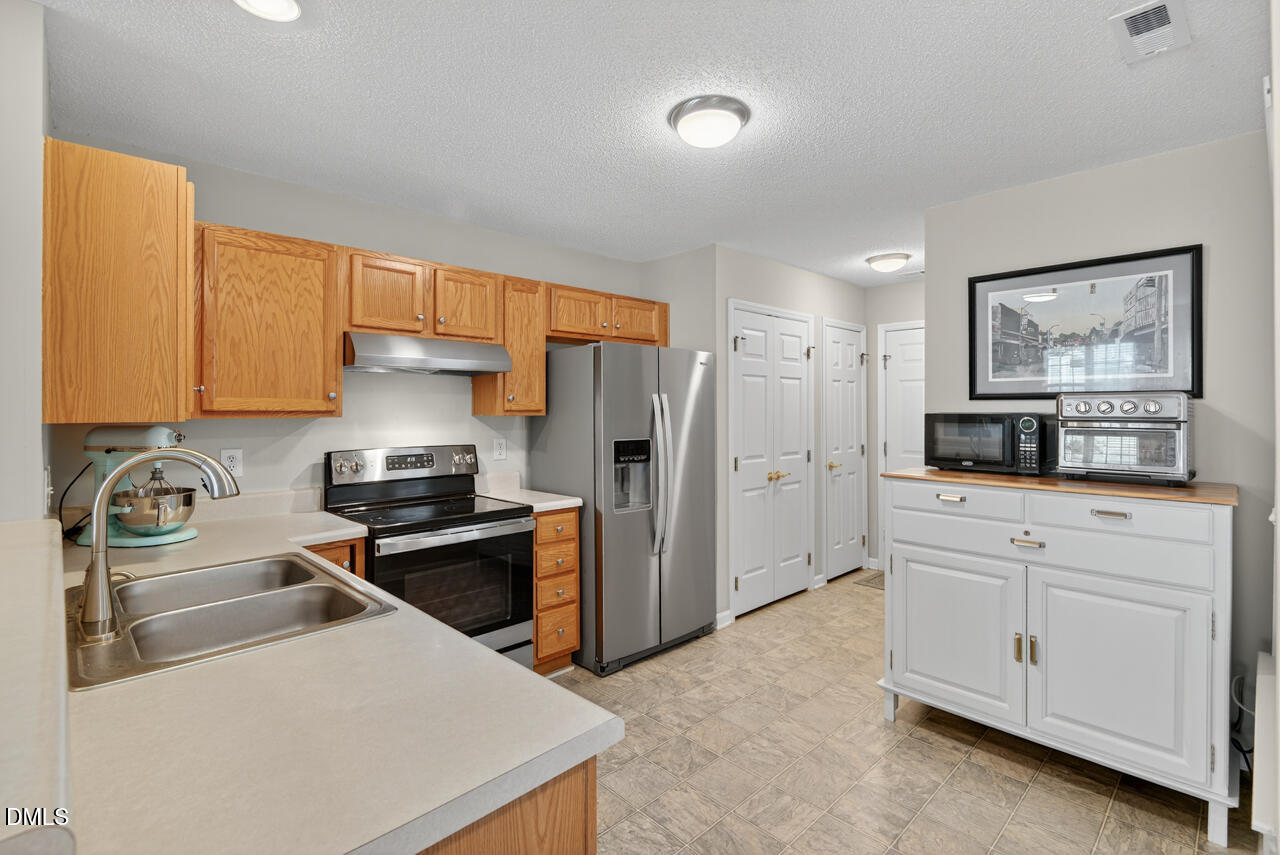 408 Intern Way Durham, NC 27713 - Photo 8 of 27 a kitchen with stainless steel appliances a refrigerator stove and sink