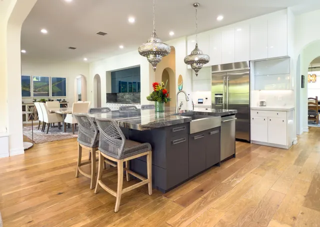 a kitchen with granite countertop white cabinets and a clock on the wall