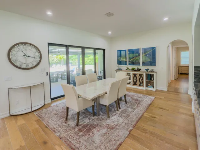 a living room with furniture a flat screen tv and a floor to ceiling window