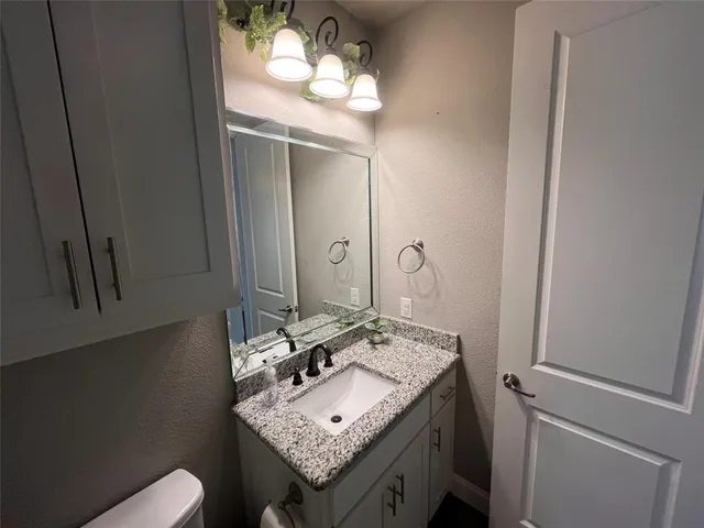 a bathroom with a granite countertop sink and a mirror