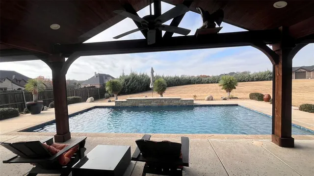 a view of swimming pool with a patio and fire pit