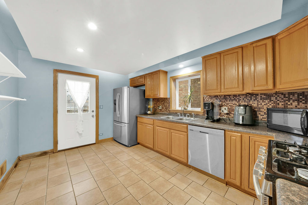 7234 South Ridgeway Avenue Chicago, IL 60629 - Photo 6 of 27 a kitchen with stainless steel appliances granite countertop a refrigerator and a stove top oven