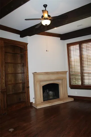 a room with wooden floor a fireplace and window