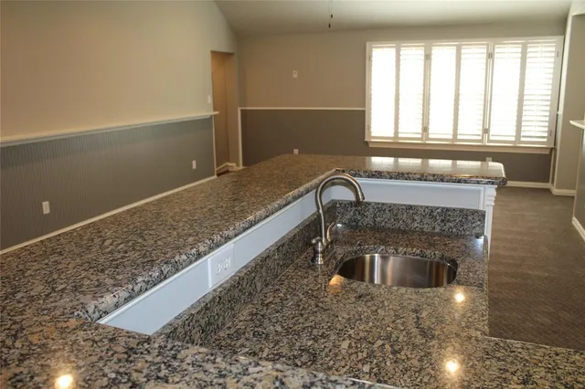 a kitchen with a sink window and stainless steel appliances