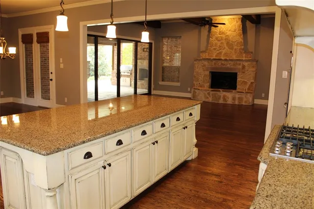 a kitchen with granite countertop a stove and a wooden floors
