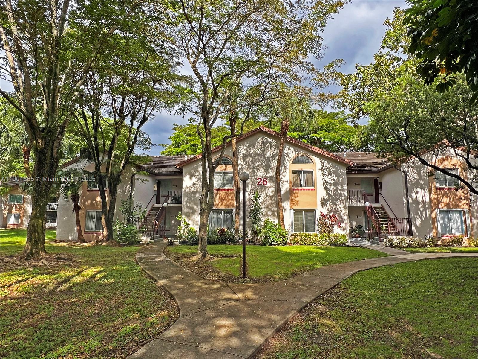 14015 Southwest 91st Terrace, Unit 14015 Miami, FL 33186 - Photo 19 of 20 a house with trees in front of it