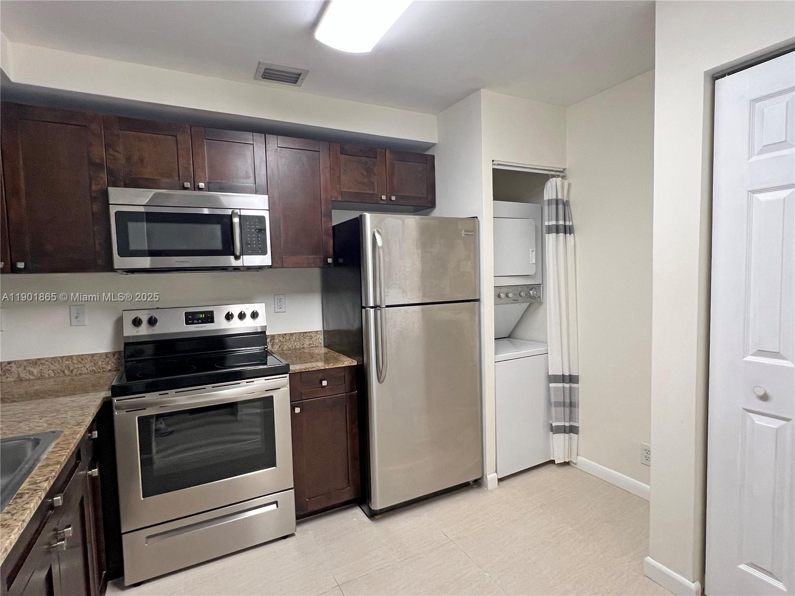 14015 Southwest 91st Terrace, Unit 14015 Miami, FL 33186 - Photo 5 of 20 a kitchen with a refrigerator stove and microwave