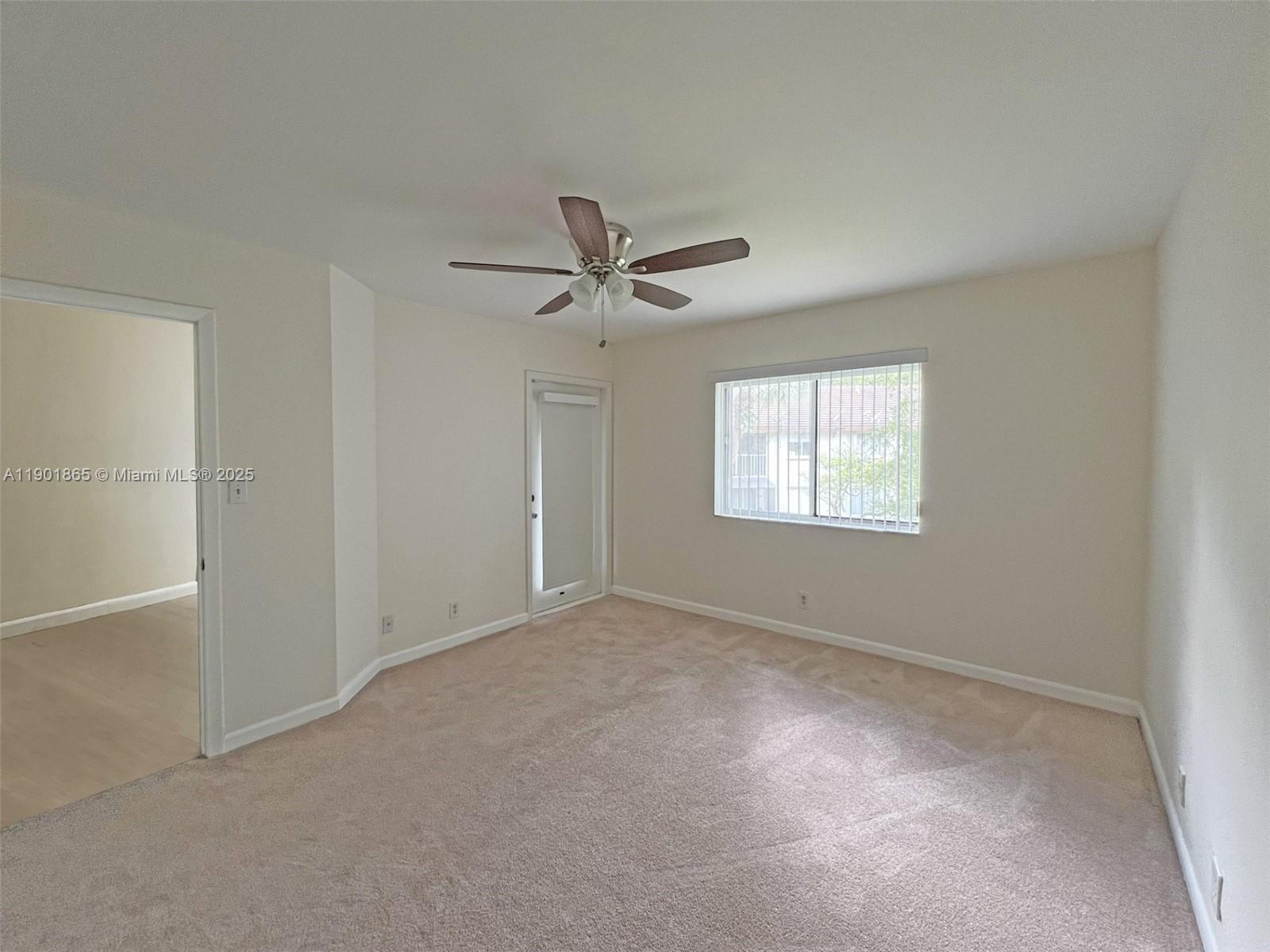 14015 Southwest 91st Terrace, Unit 14015 Miami, FL 33186 - Photo 6 of 20 an empty room with windows and ceiling fan