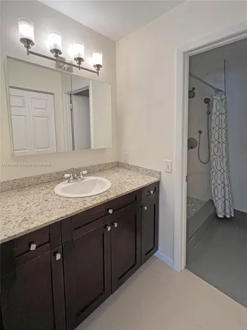 a bathroom with a granite countertop sink and a mirror