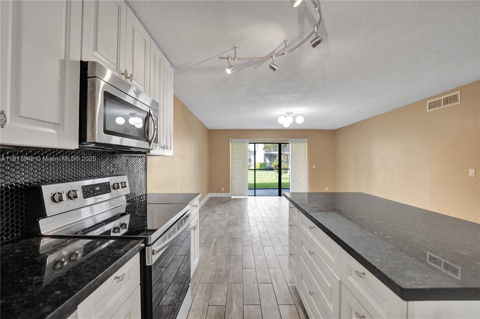 304 Racquet Club Road, Unit 105 Weston, FL 33326 - Photo 8 of 41 a kitchen with stainless steel appliances granite countertop a stove a sink and a microwave